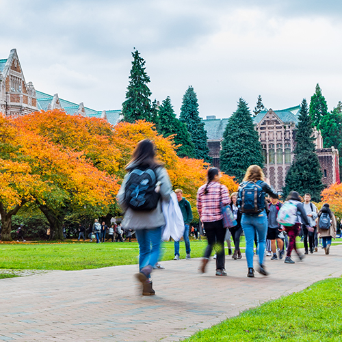Students walking across the quad with colorful autumn trees