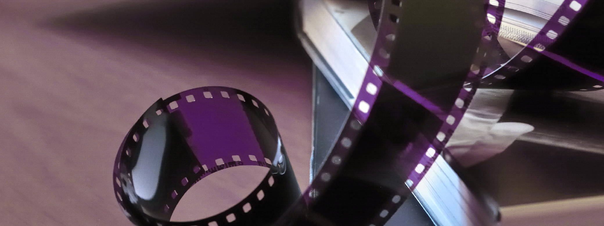 Close-up shot of purple roll of film curling on a table.