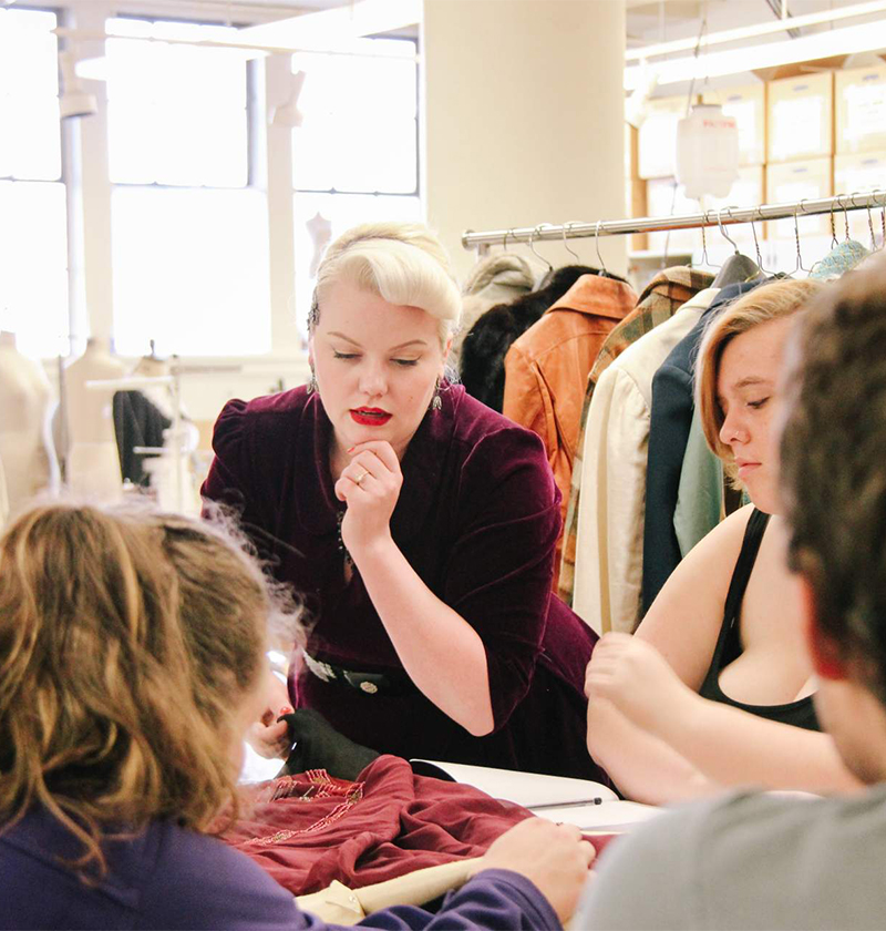 Students discussing a costume in the School of Drama costume shop.