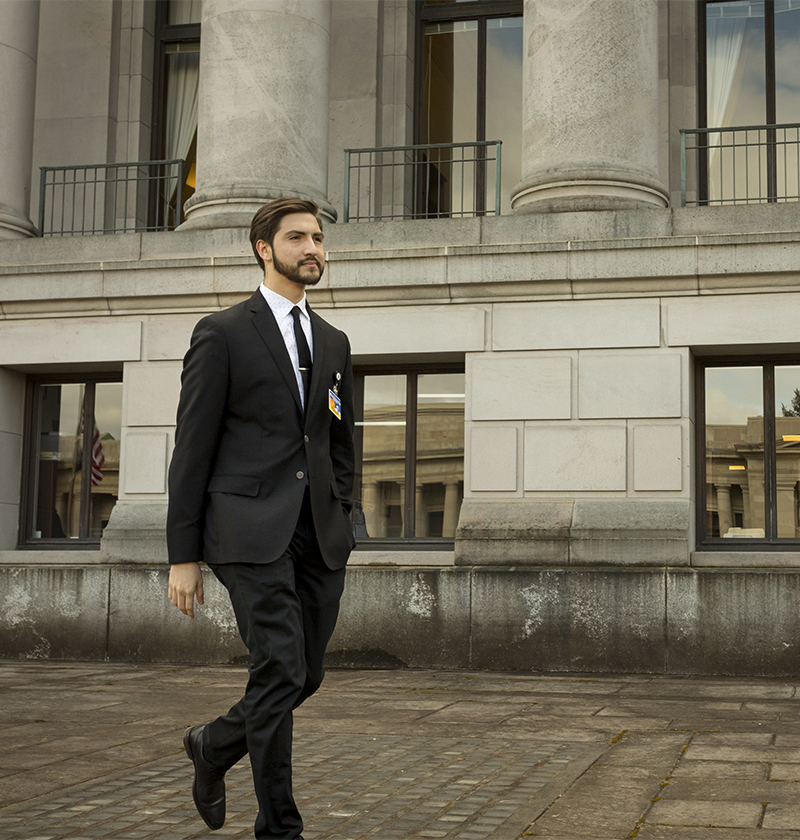 A UW Political Science student walks outside the State Capitol Building in Olympia, Washington during an internship.