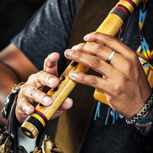 Close up of someone's hands playing a wind instrument.