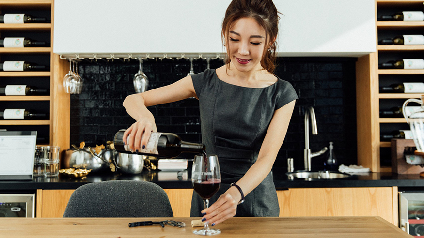 Danni Lin pouring wine in the company's wine tasting room.