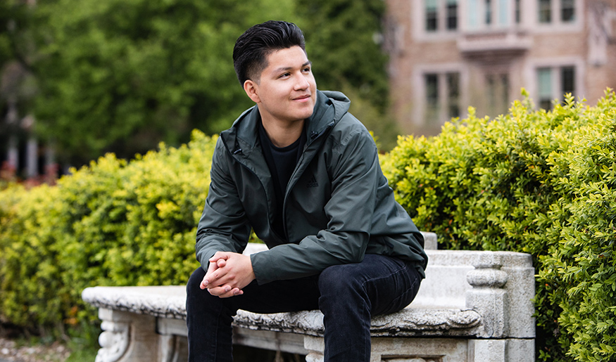Will Sanchez sitting on a bench on the UW campus.