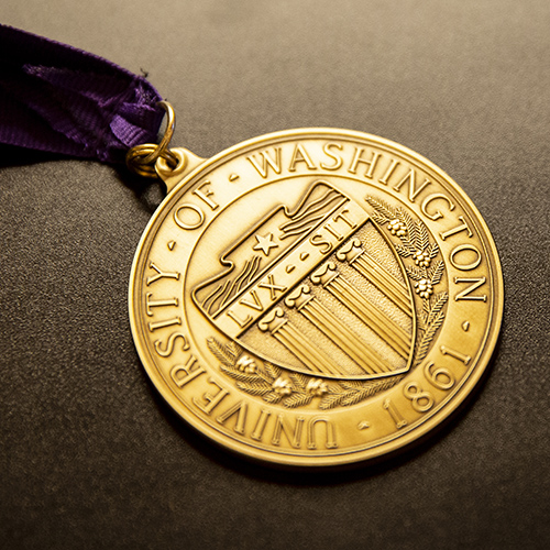 A gold University of Washington medal on a ribbon